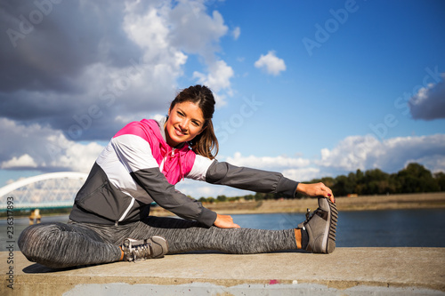 Young woman stretching before running outdoors