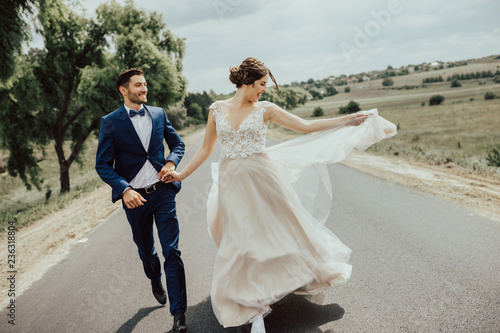 Фотография Wedding couple running on the road