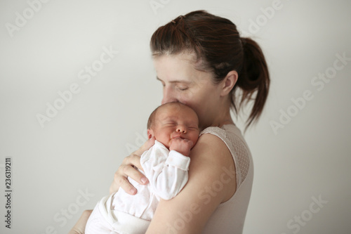 Gentle mother holds sleeping newborn baby
