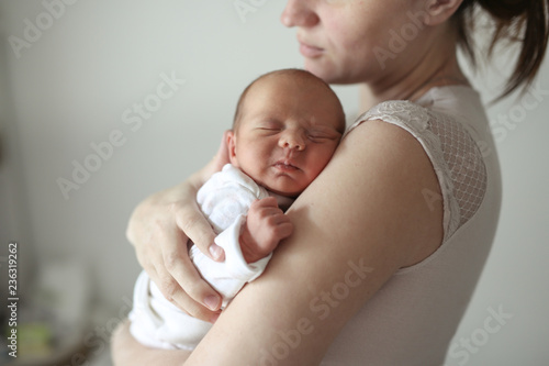 Gentle mother holds sleeping newborn baby