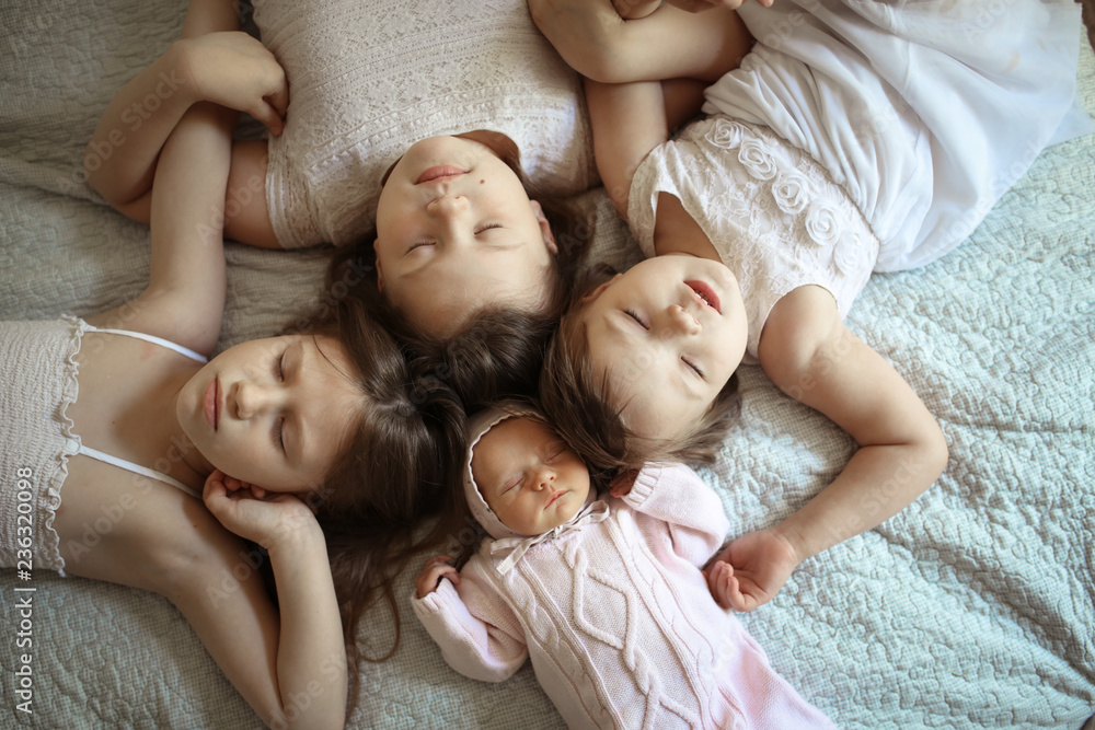 funny children together on bed, four sisters