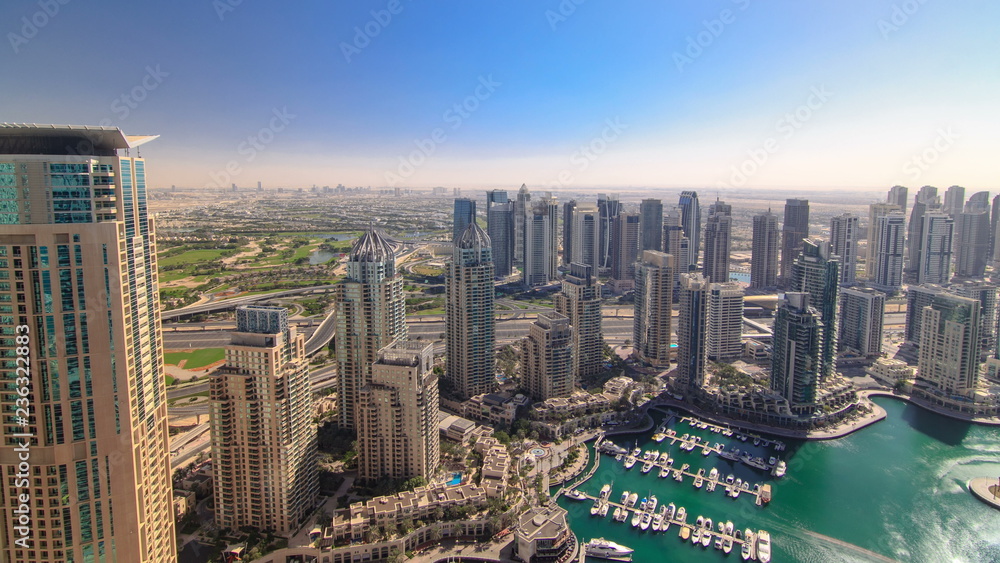 Fototapeta premium Modern buildings in Dubai Marina with shadows moving very fast timelapse, Dubai, UAE.