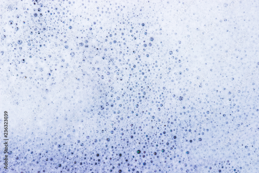 White bubble of detergent in blue container for background. Abstract texture. White bubble of detergent in blue container for background. Abstract texture.