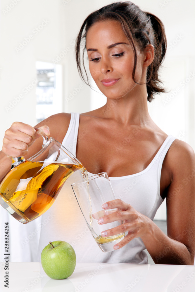 WOMAN POURING APPLE JUICE WOMAN POURING APPLE JUICE