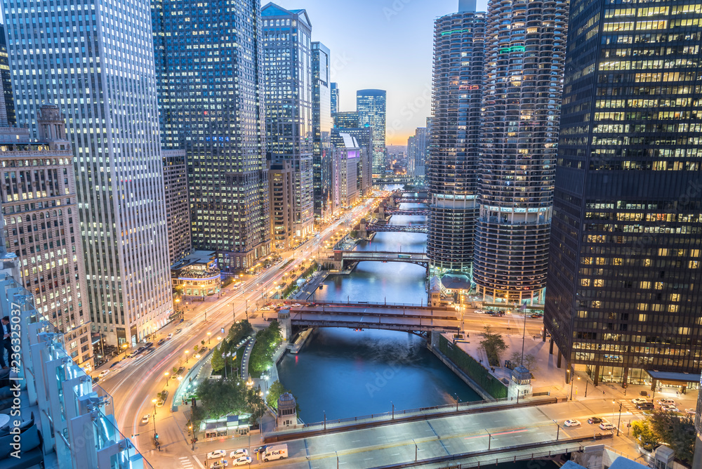 Obraz premium Aerial view of skyline along Chicago river through downtown at sunset