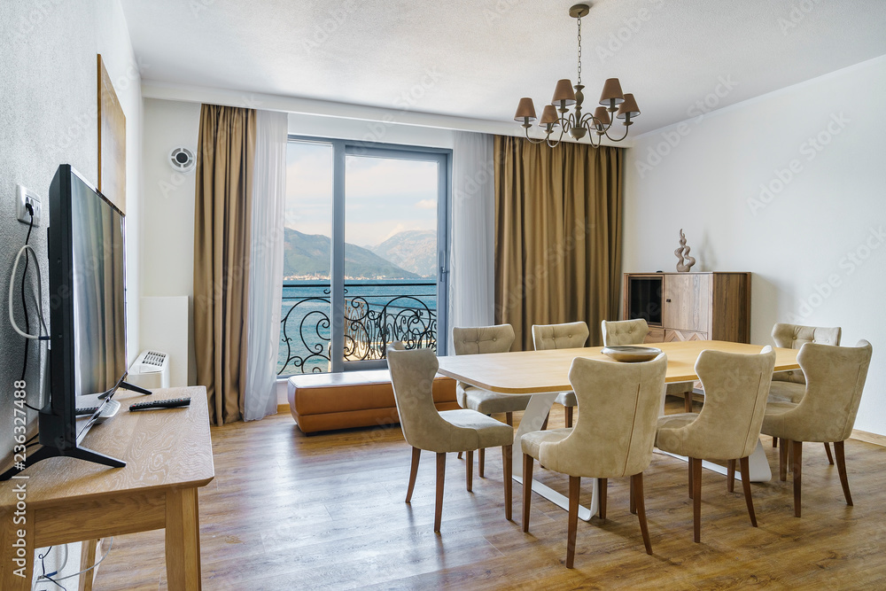 Interior of light spacious living room with a picturesque mountain and sea view in a luxury villa