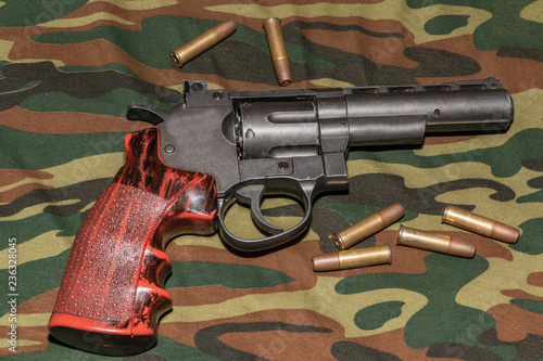 Revolver on camouflage background. Pneumatic gun 4,5 mm