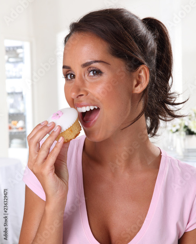 WOMAN EATING A CUPCAKE