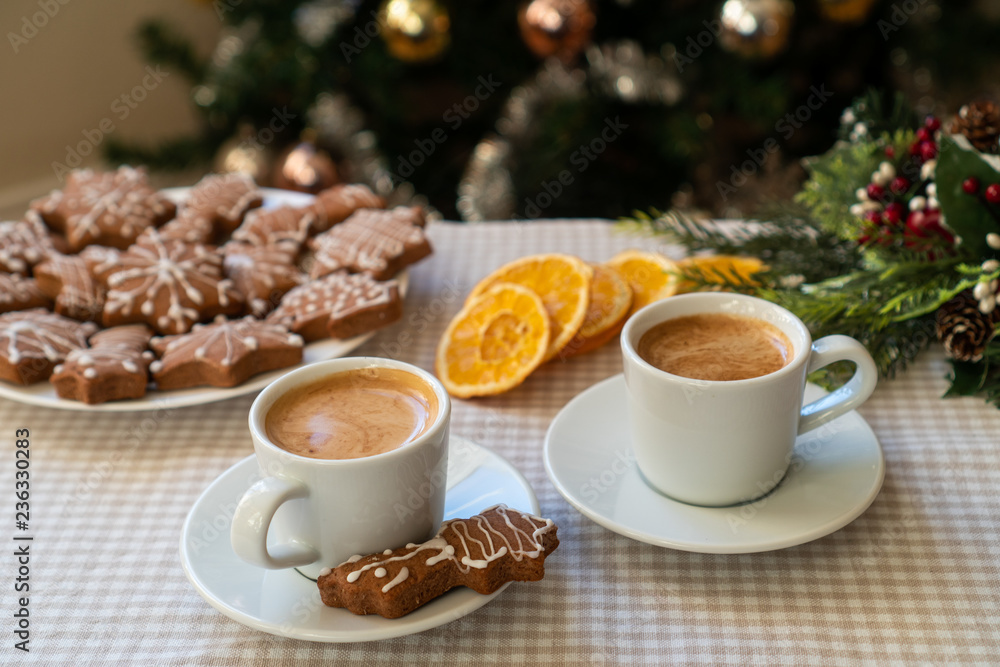 Having coffee together in a Christmas mood. Two espresso cups on a table with gingerbread cookies in a warm Winter Holidays decor. Having coffee together in a Christmas mood. Two espresso cups on a table with gingerbread cookies in a warm Winter Holidays decor.