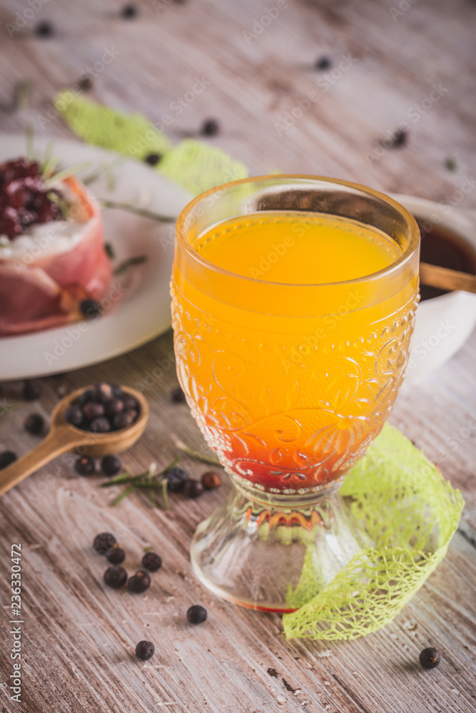 Fototapeta premium Glass with orange juice on wooden board with whole camembert