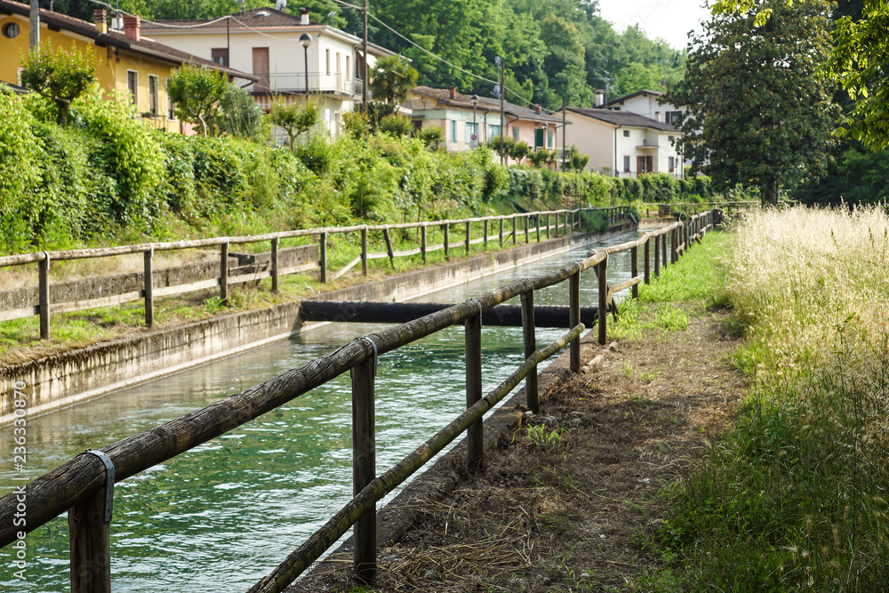 An irrigation canal wends its way through italy farmland . An irrigation canal wends its way through italy farmland .