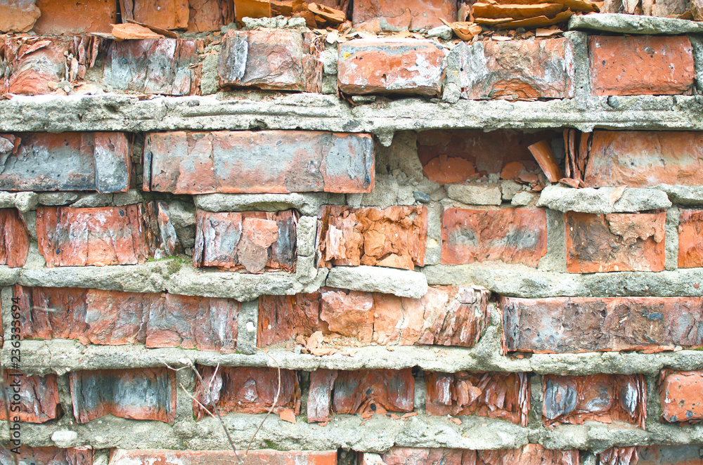 Fotografie old crumbling and weathered brickwork covered in cracks-background image