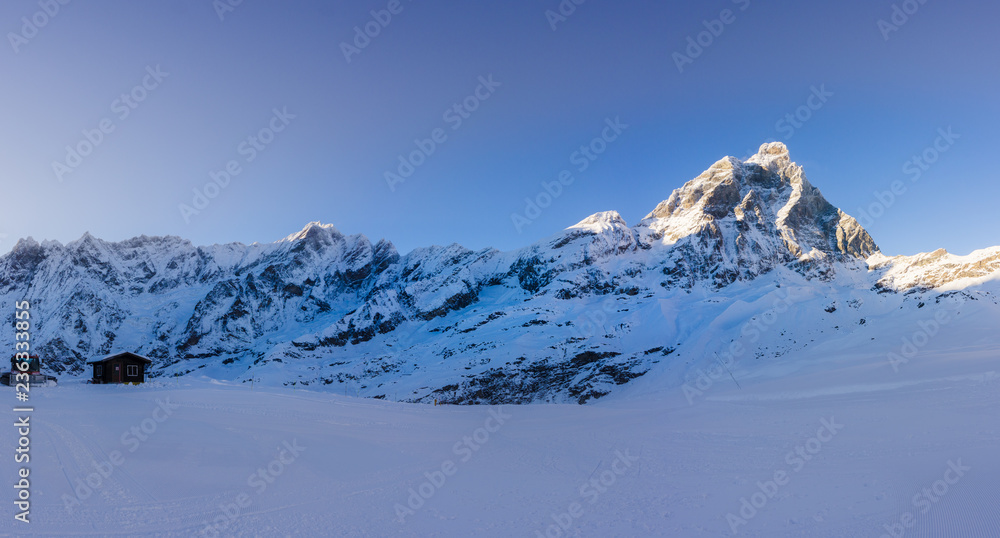 Landscape panoramic of the Matterhorn mountain with snow and a blue sky
