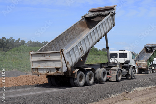 road repair, trucks brought sand, stones in order to fold the new asvalt photo