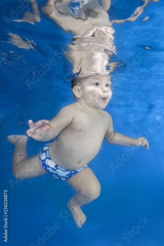 Boy swim underwater in the swimming pool on a blue water background. Healthy family lifestyle and children water sports activity. Child development, disease prevention © Andriy Nekrasov