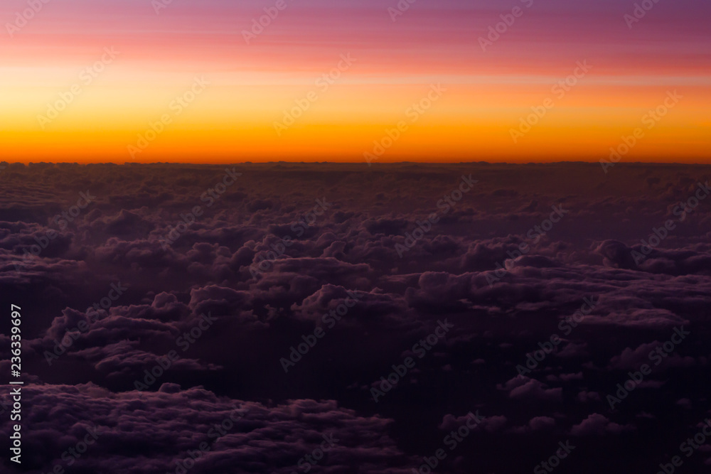 Pink and orange sunset sky over clouds. Colorful cloudscape views from airplane. Background texture, horizon, dream concepts