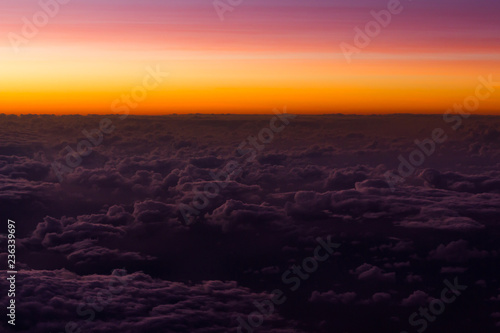 Pink and orange sunset sky over clouds. Colorful cloudscape views from airplane. Background texture, horizon, dream concepts © Josu Ozkaritz