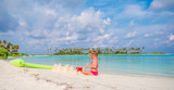 Adorable little girl playing with beach toys during tropical vacation