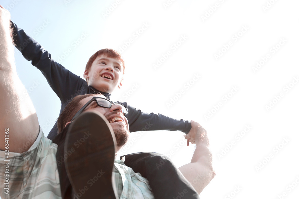 happy father holds his son on his shoulders - obrazy, fototapety, plakaty 
