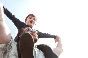happy father holds his son on his shoulders