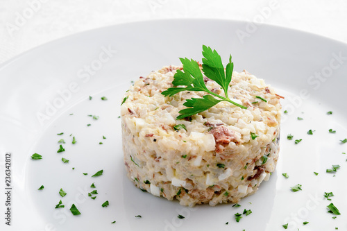 mackerel salad with egg, onion and rice dressed with mayo sauce and  decorated with parsley
