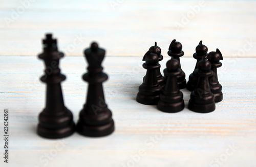 chess pieces pawns stand in a crowd amid the king and queen