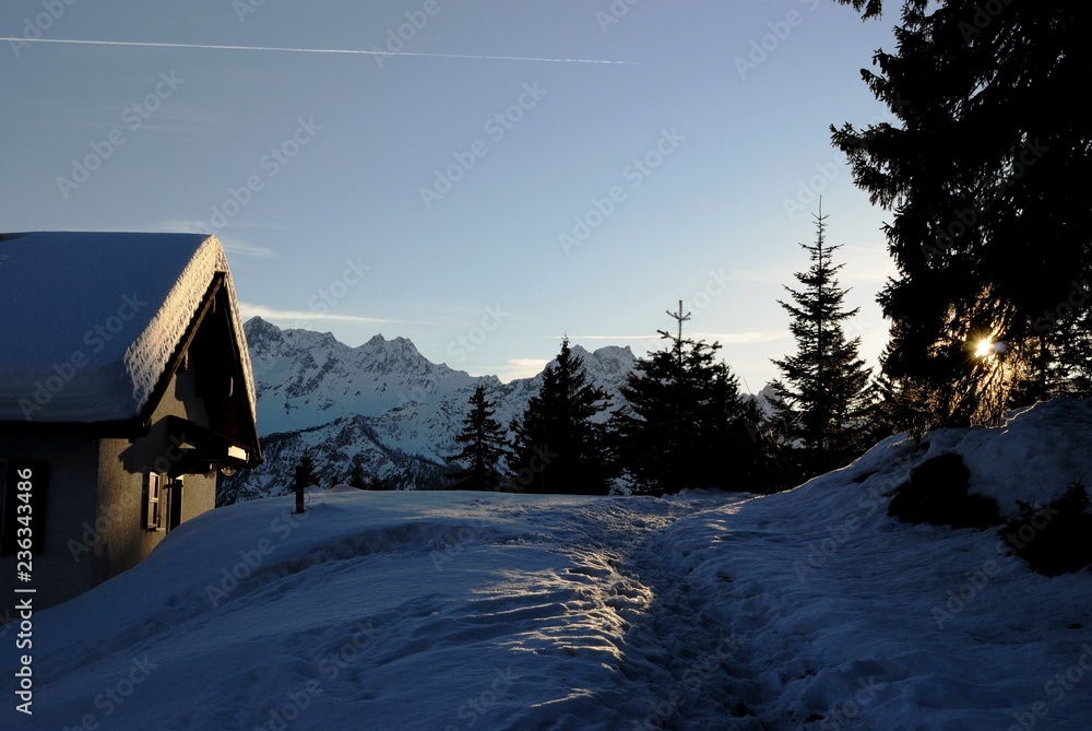 Fotografie Cabina al tramonto con neve e raggio di sole