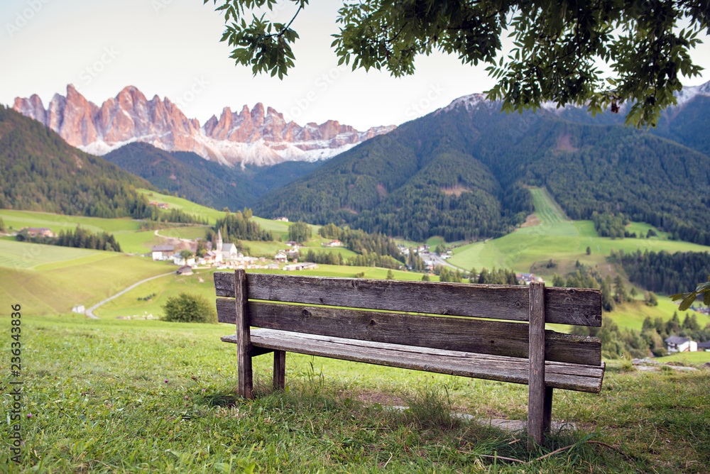 bench with view on Santa Maddalena ,St Magdalena, village with Dolomites mountains on background, Val di Funes valley, Trentino Alto Adige region, Italy, Europe
