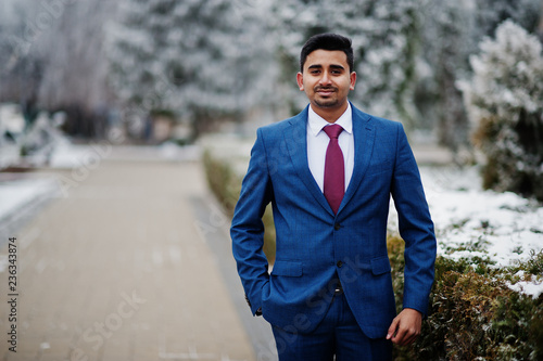 Elegant indian fashionable man model on suit posed at winter day.