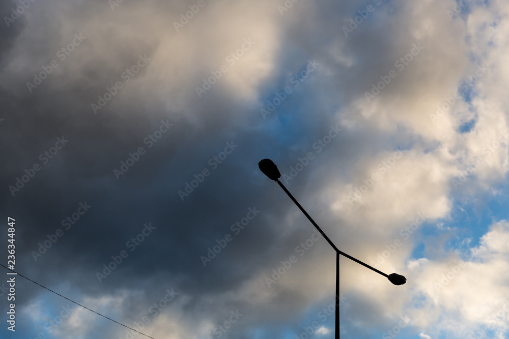 Street lamp against a background of sky and puffy clouds. Street light against blue sky and beautiful clouds. 