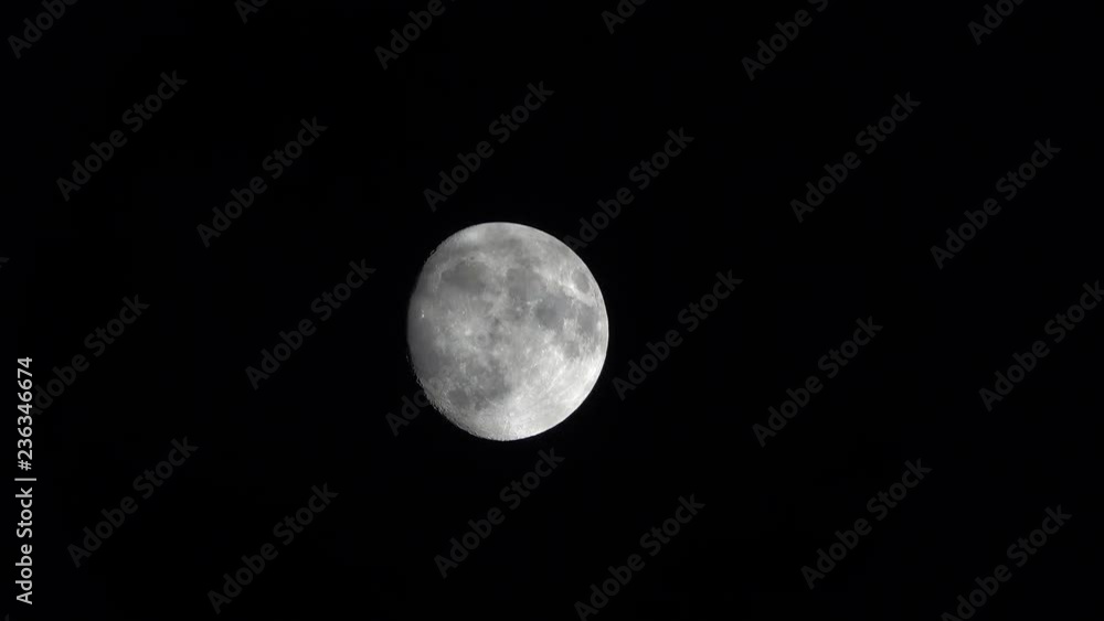 Clouds pass in front of a nearly full moon, set against a solid black night sky, while a distant object (most likely a satellite, technically a UFO) crosses the moon from right to left. Clouds pass in front of a nearly full moon, set against a solid black night sky, while a distant object (most likely a satellite, technically a UFO) crosses the moon from right to left.