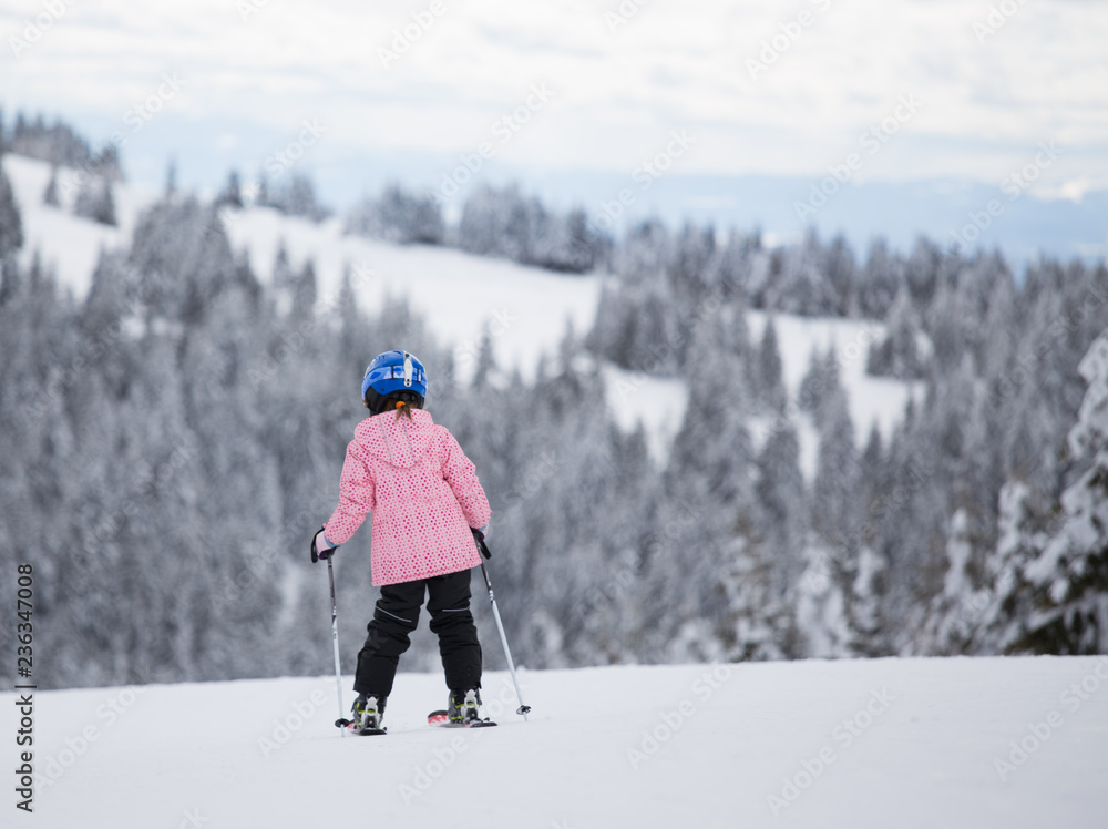 Young girl skiing on mountain slope