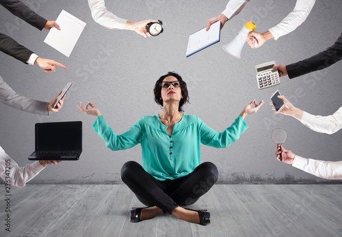 Businesswoman tries to keep calm with yoga due to stress and overwork at wok photo