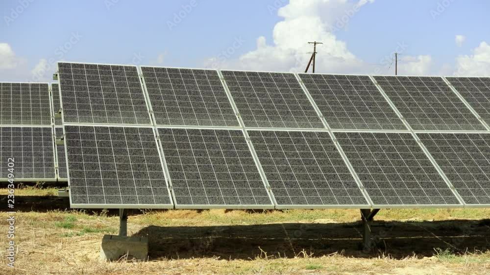 Large dusty solar panels in the field under the clear blue sky. Huge sun power plant in the wild. Concept of green natural energy collection. Clean and environment friendly electricity source. Large dusty solar panels in the field under the clear blue sky. Huge sun power plant in the wild. Concept of green natural energy collection. Clean and environment friendly electricity source.