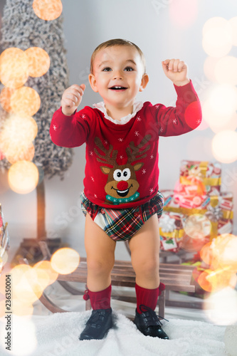 Merry Christmas. Happy little child is wearing a funny Christmas sweater at home.