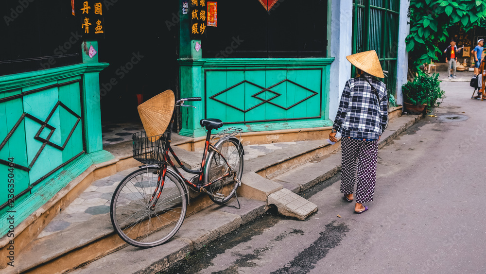 A woman wearing a traditional hat in Hoi An