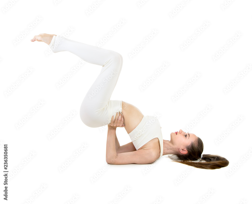 A young woman in a white suit performs acrobatic elements and yoga. A young woman in a white suit performs acrobatic elements and yoga.