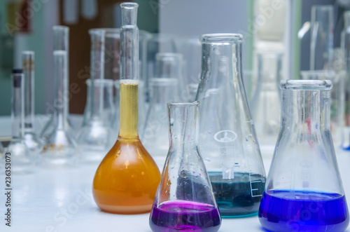 Laboratory glassware with multi-colored liquid on table. Chemical analysis
