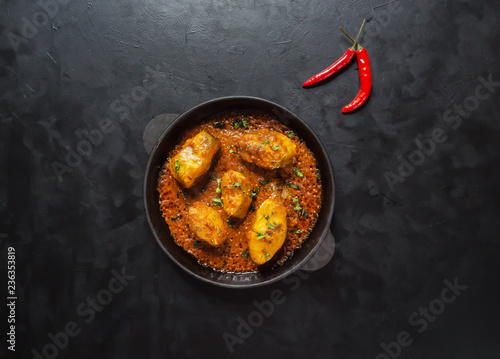 Top view of spicy and hot Bengali fish curry. Indian food. Fish curry with red chili, curry leaf, coconut milk. Asian cuisine.

