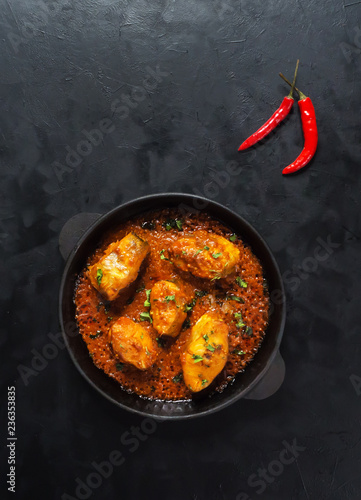 Top view of spicy and hot Bengali fish curry. Indian food. Fish curry with red chili, curry leaf, coconut milk. Asian cuisine.
