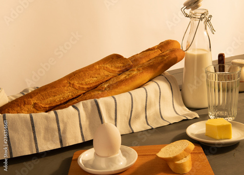 Завтрак с яйцом всмятку французским багетом и молоком