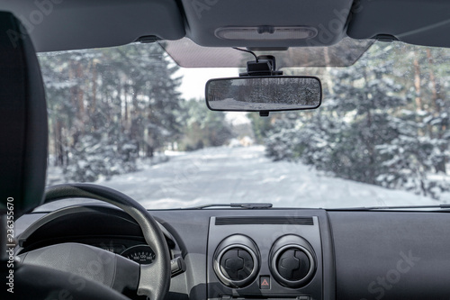 Inside view from car vehicle at snowy road in forest. Winter off road trip. © FedBul