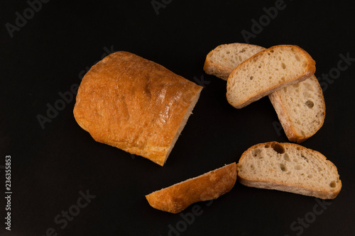 Нарезанная белая булка на черном фоне