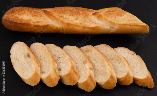 Нарезанный французский багет на черном фоне
