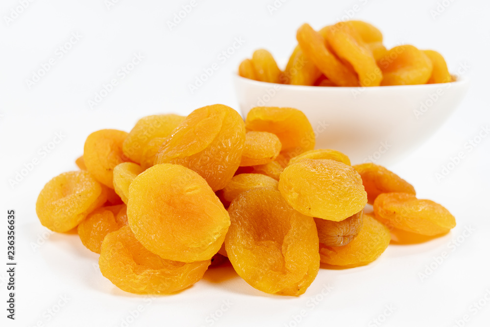 Tasty dried apricots in a white bowl. Treats for cakes on the kitchen table. Tasty dried apricots in a white bowl. Treats for cakes on the kitchen table.