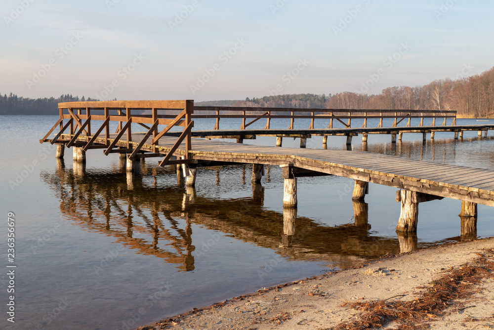 Wooden old bridge over the lake. A place of summer recreation after the tourist season.