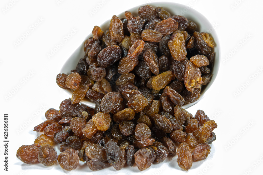 Tasty raisins in a white bowl. Treats for cakes on the kitchen table.