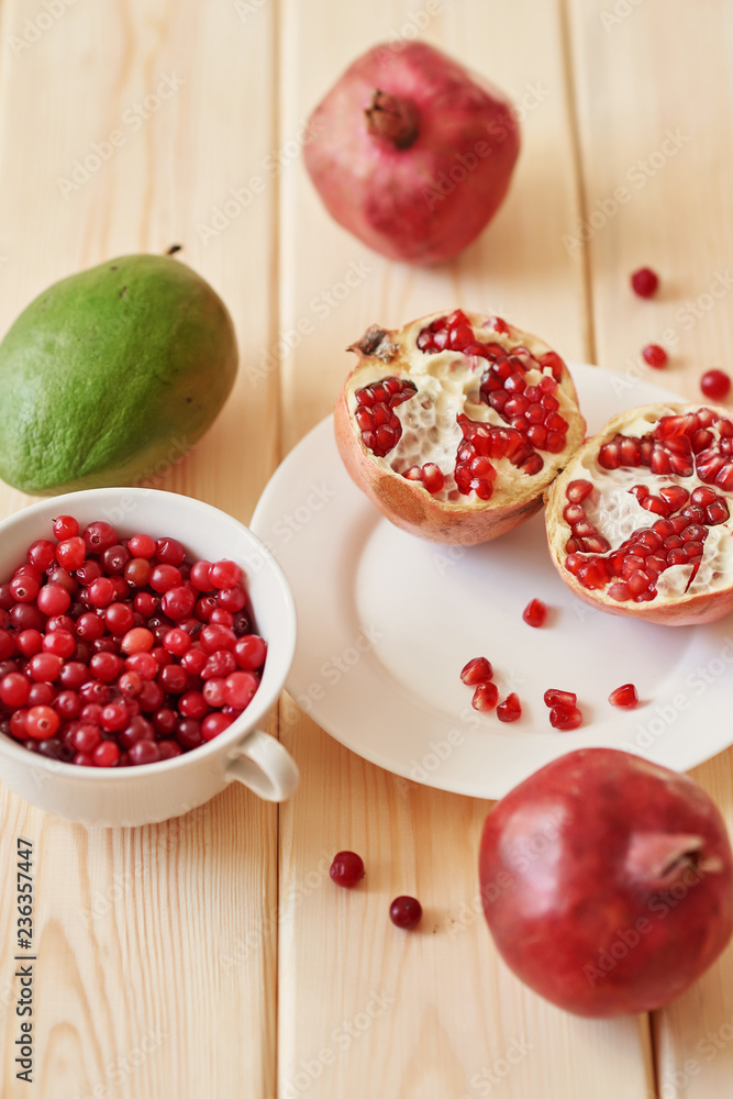 pomegranate, grapes, lime and cranberries on a wooden surface pomegranate, grapes, lime and cranberries on a wooden surface
