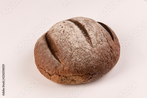 Булка черного хлеба на белом фоне
