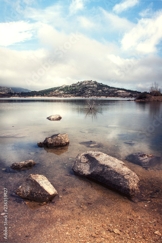 ROCAS EN LA ORILLA Y MONTAÑA AL FONDO